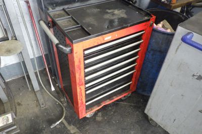 une armoire à outils rouge comportant de nombreux tiroirs, dans un garage