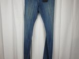 a pair of jeans hanging on a hanger in front of a white curtain