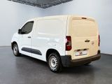 the white van is parked in a large room with a black floor