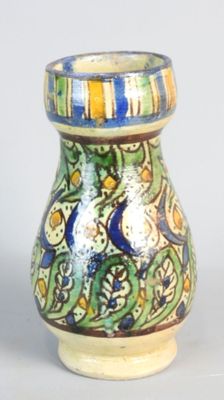 un petit vase orné d'un motif bleu et jaune