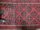 a person standing on a rug with a pair of black shoes