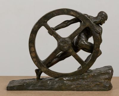 statue of a man holding a wheel on a wooden base