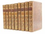 six vieux livres sont alignés sur une surface blanche