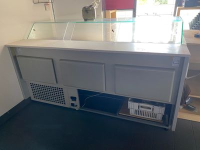 une photo d'un comptoir de magasin avec une vitrine en verre