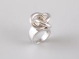 a close up of a silver ring with a knot on it