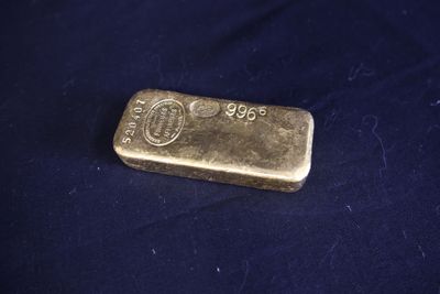 un lingot d'or posé sur un tissu bleu