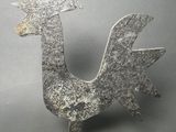 an image of a metal sculpture of a rooster on a stand
