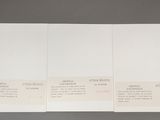 two pages of white paper on a gray surface with a black background