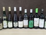 Des bouteilles de vin sont alignées sur une table devant un fond marron.