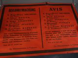 un panneau orange avec une inscription noire, posé sur une table
