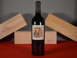 une bouteille de vin posée sur une table, à côté de deux caisses en bois