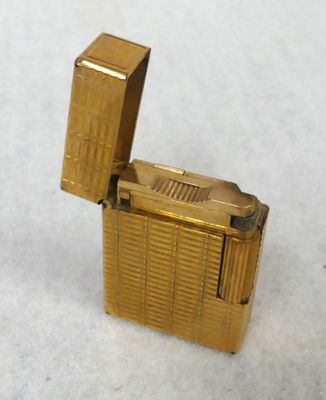 a gold lighter that is sitting on a white surface