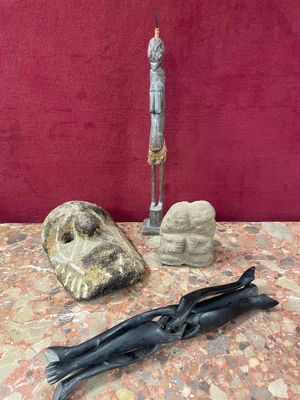 a statue of a man standing next to a knife on a table
