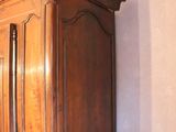 a wooden armoire in the corner of a room