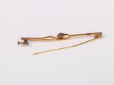a close up of a pair of gold hair pins on a white surface