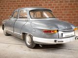 a silver car that is parked in front of a brick wall
