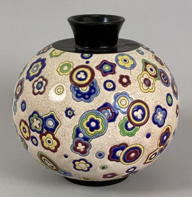 a vase with a colorful design on it sitting on a table