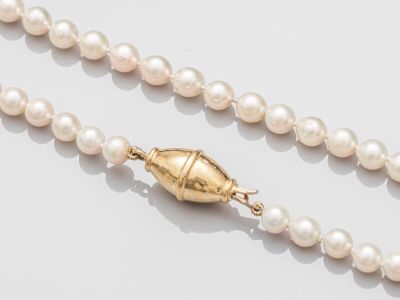 gros plan d'un collier de perles sur une surface blanche