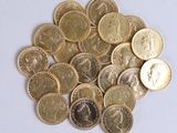 a pile of gold coins on a white surface