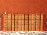 une pile de livres posée sur une table, avec un mur rouge en arrière-plan