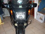 une moto noire garée dans un garage, équipée d'un radiateur