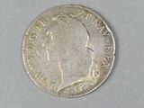 an old silver coin with a profile of a man on it