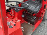 a red tractor with a black seat sitting on the back of it
