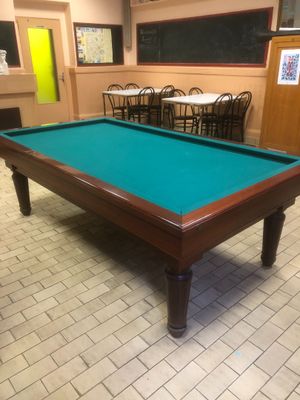 une table de billard placée au milieu d'une pièce