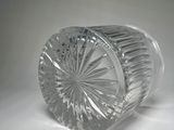 clear glass vase on a white surface with a gray background