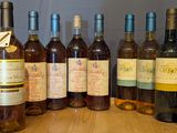 several bottles of wine are lined up on a wooden table