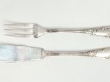 two forks and a knife on a white table