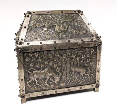 an old silver box with a design of animals on it