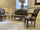 trois chaises et un canapé dans une pièce avec une statue en arrière-plan