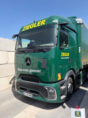 un gros camion vert garé sur un parking