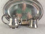 a silver plate with two silver cups and a silver plate with a mirror on it