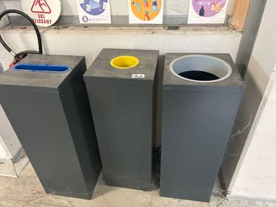 three trash cans sitting next to each other on the floor