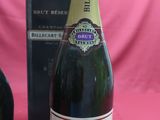 bottles of champagne and a bottle of wine on a pink background