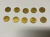 a bunch of gold coins sitting on top of a white table