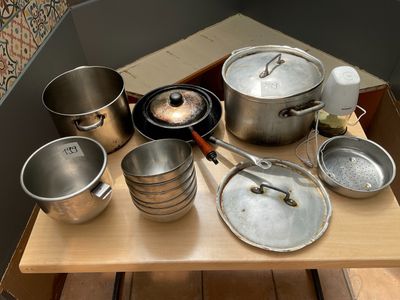 many pots and pans sitting on a wooden table