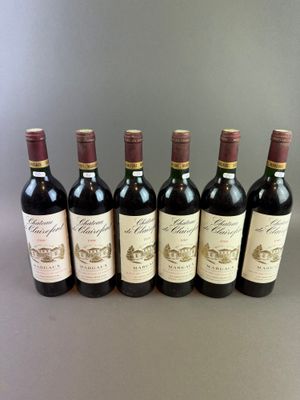 six bottles of wine lined up in a row on a table