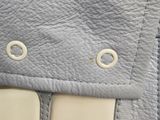 the inside of a gray purse with a pair of scissors sticking out of it