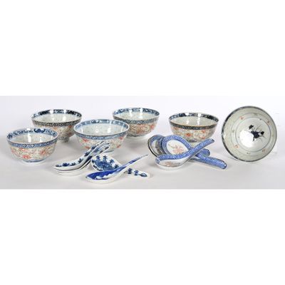 several bowls and spoons are lined up on a white surface