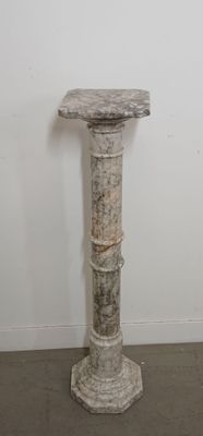 a marble pedestal in the corner of a room