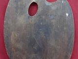 une palette en bois percée d'un trou, posée sur un fond rouge