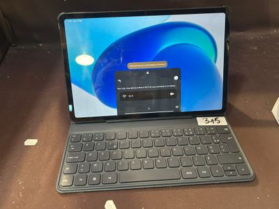 un ordinateur portable posé sur une table, avec un clavier dessus