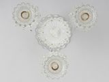 three glass wall sconces on a white wall with a white background