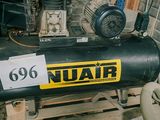 un compresseur d'air noir posé sur une palette dans un garage