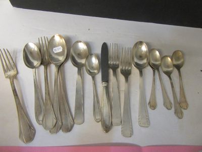 un grand nombre de cuillères et de fourchettes disposées sur une table