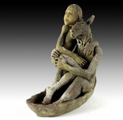 sculpture représentant une femme assise sur un rocher, tenant un chat dans ses bras
