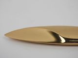 a close up of a gold object on a white surface